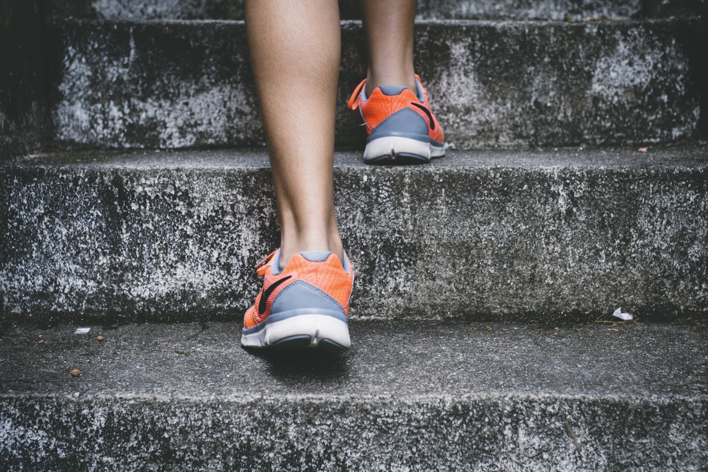 Läuferin in Sportschuhen steigt eine Treppe hinauf